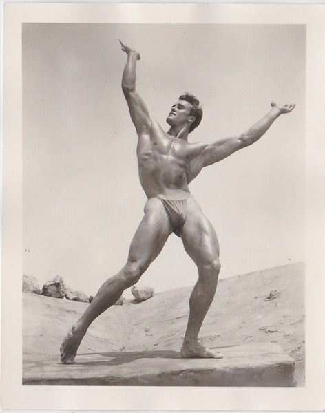 Ed Fury holds an imaginary world above his head like the mighty Atlas. Vintage physique photo.