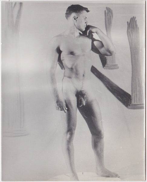 Unidentified male nude stands with one hand on his shoulder recalling Michelangelo's David. 