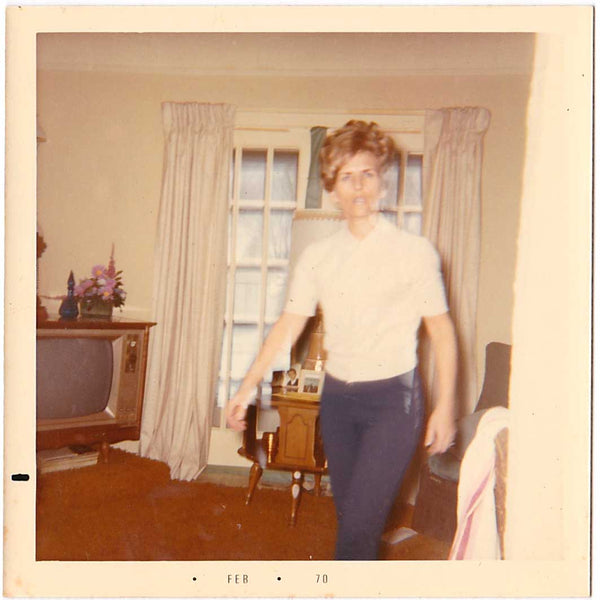 Vintage color snapshot of a person striding across the living room.