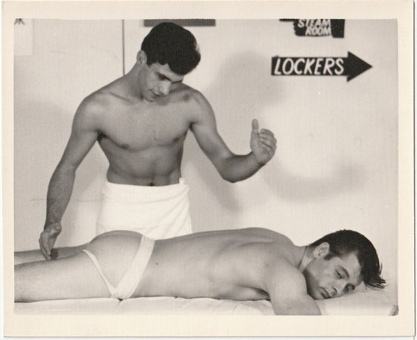 Original vintage gay photo of a masseur wearing a towel about to start rubbing his jockstrap wearing buddy. By Chuck Renslow - Kris Studio, Chicago.
