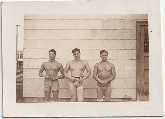 sepia photo of three studly bodybuilders posing in front of a wall. They're identified on verso as "Swag," Don, and Gus. Gay interest.