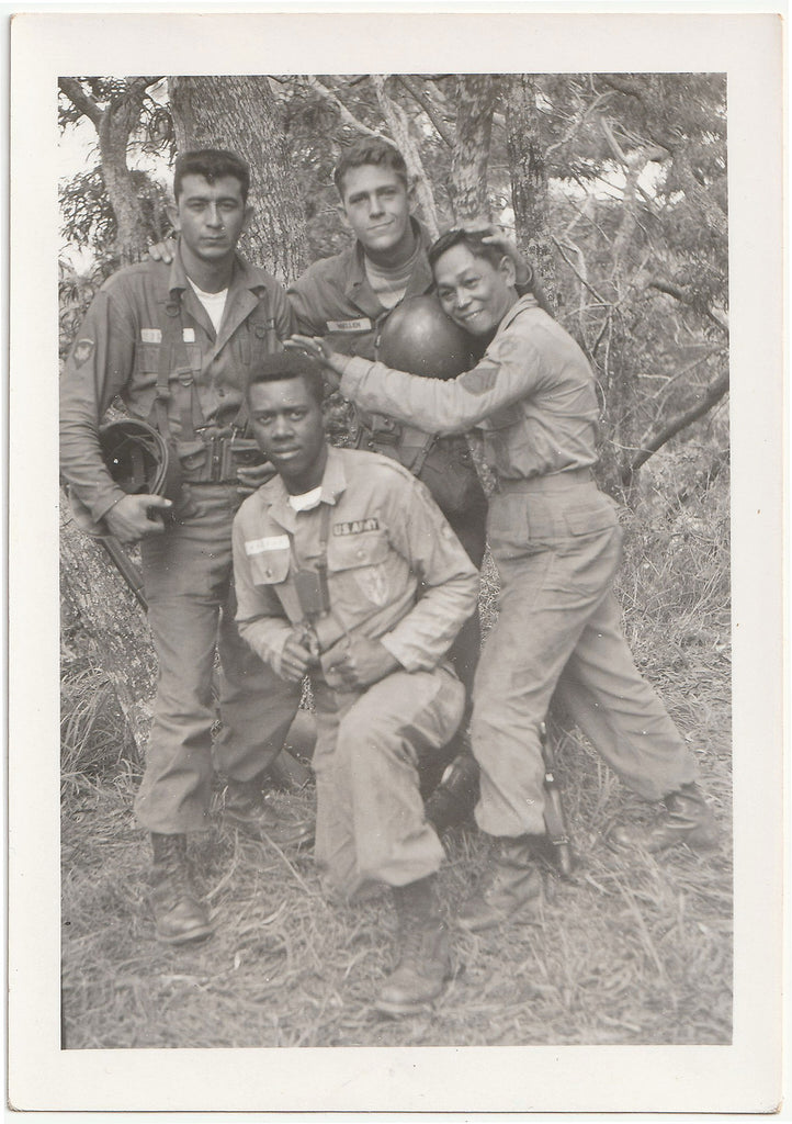 Unusual, racially diverse group of four affectionate soldiers posing in a forest vintage photo 1950s