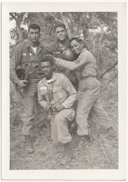 Unusual, racially diverse group of four affectionate soldiers posing in a forest vintage photo 1950s