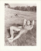 Beautifully printed photo of a handsome bodybuilder lying on the grass, revealing his biceps and abs. Signed and stamped on verso: "Paul Burkhart, San Diego, Calif." 