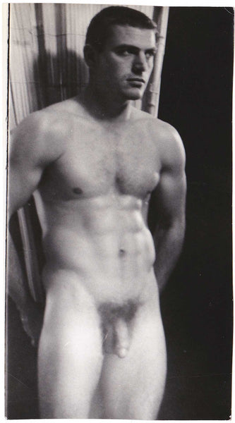 Vintage gay photo Handsome hunk stands with his hands behind his back.