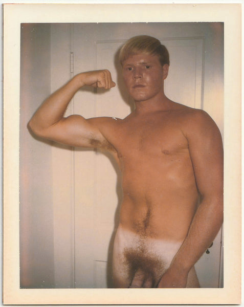 Vintage gay Polaroid Good looking, sweaty, blond muscle guy with tan lines flexes his biceps in front of what looks like the bathroom door. 