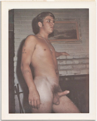 Looming above the brick fireplace must be curiously exciting for his handsome blond guy. 3 1/2" x 4 1/4" vintage gay Polaroid c. 1965.