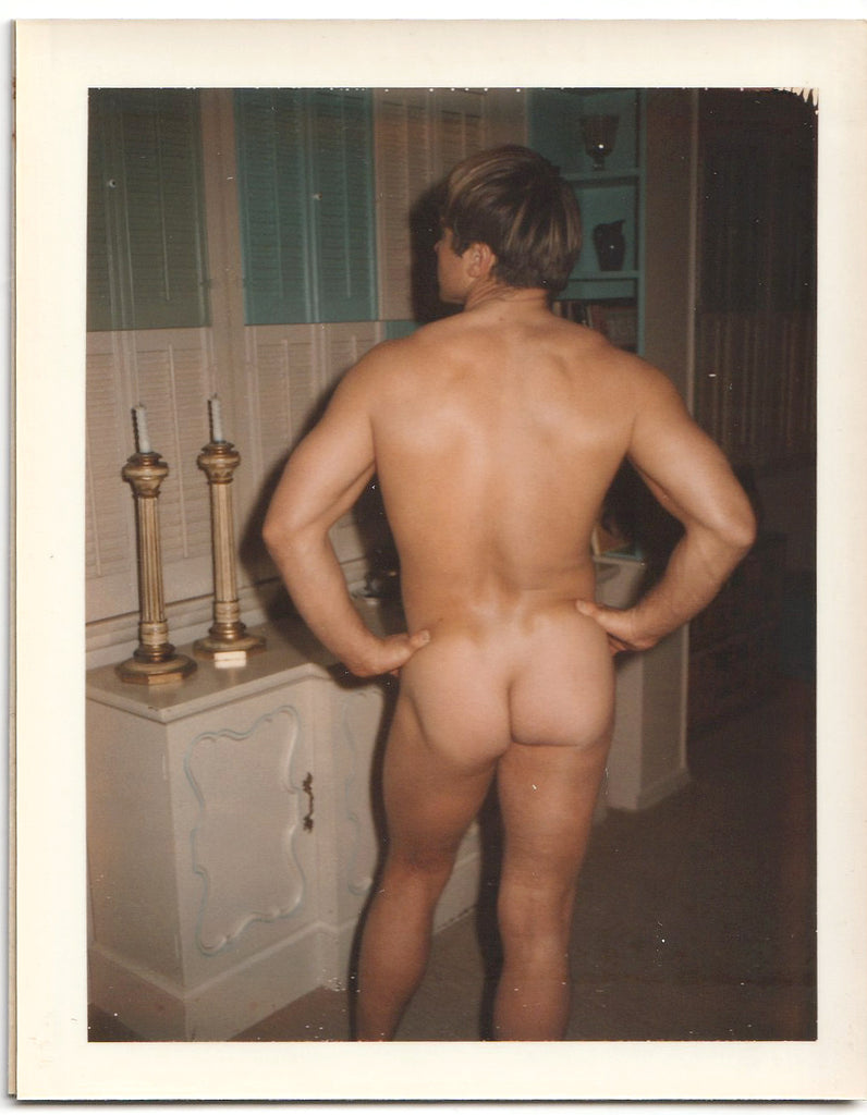 Muscular wrestler offers up his prodigious posterior vintage color Polaroid c. 1965.