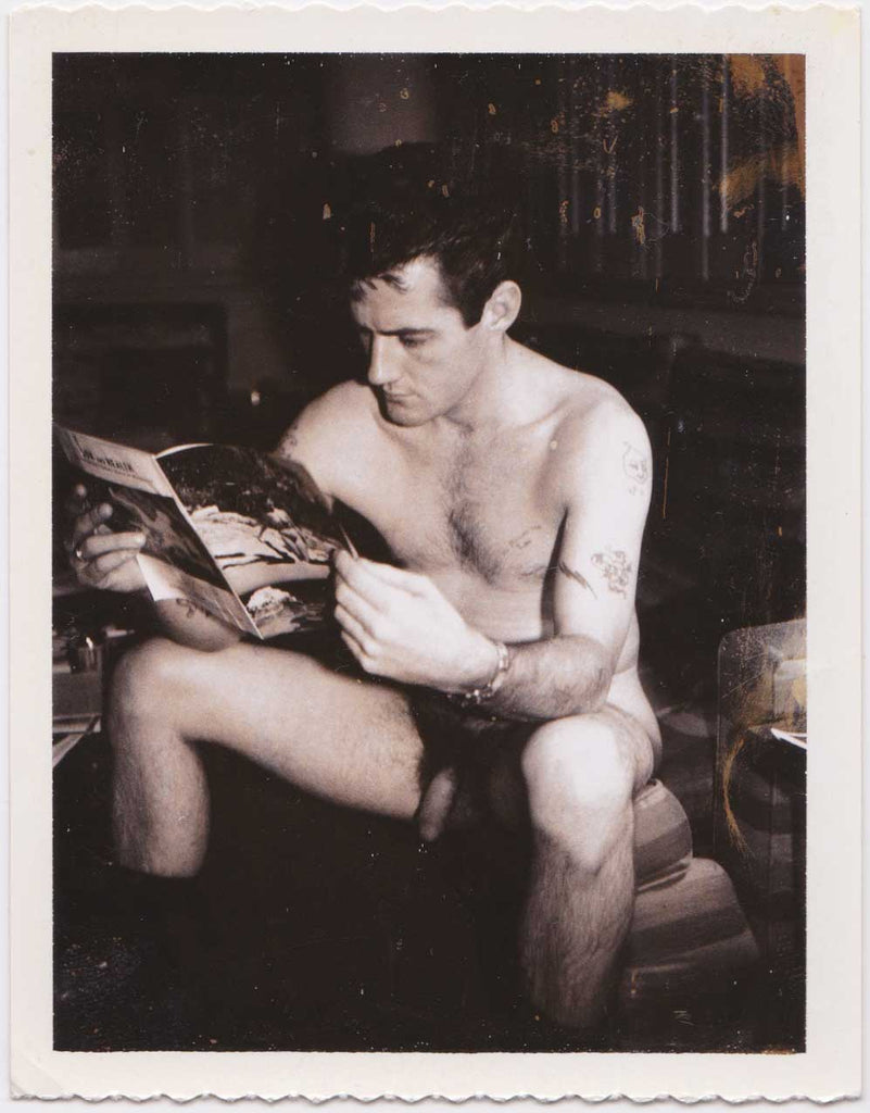 vintage gay polaroid Naked man looking at a straight porn magazine. 