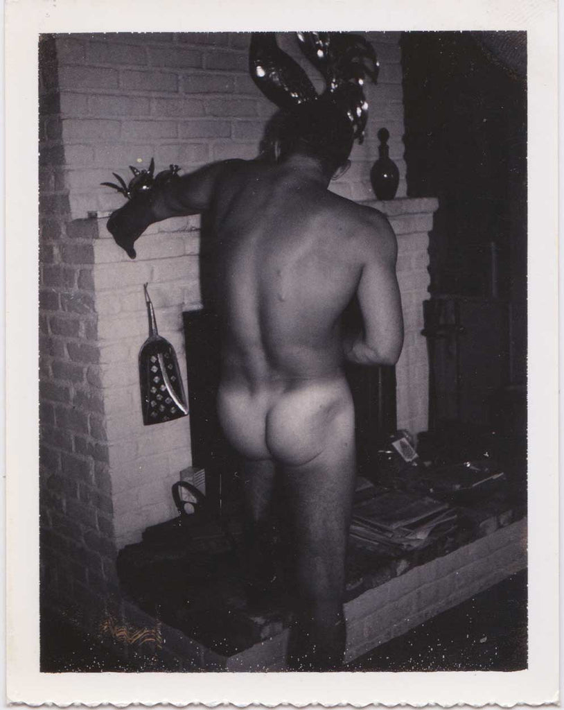 Vintage Polaroid Naked guy with his back to the camera rests his hand on the fireplace mantel.