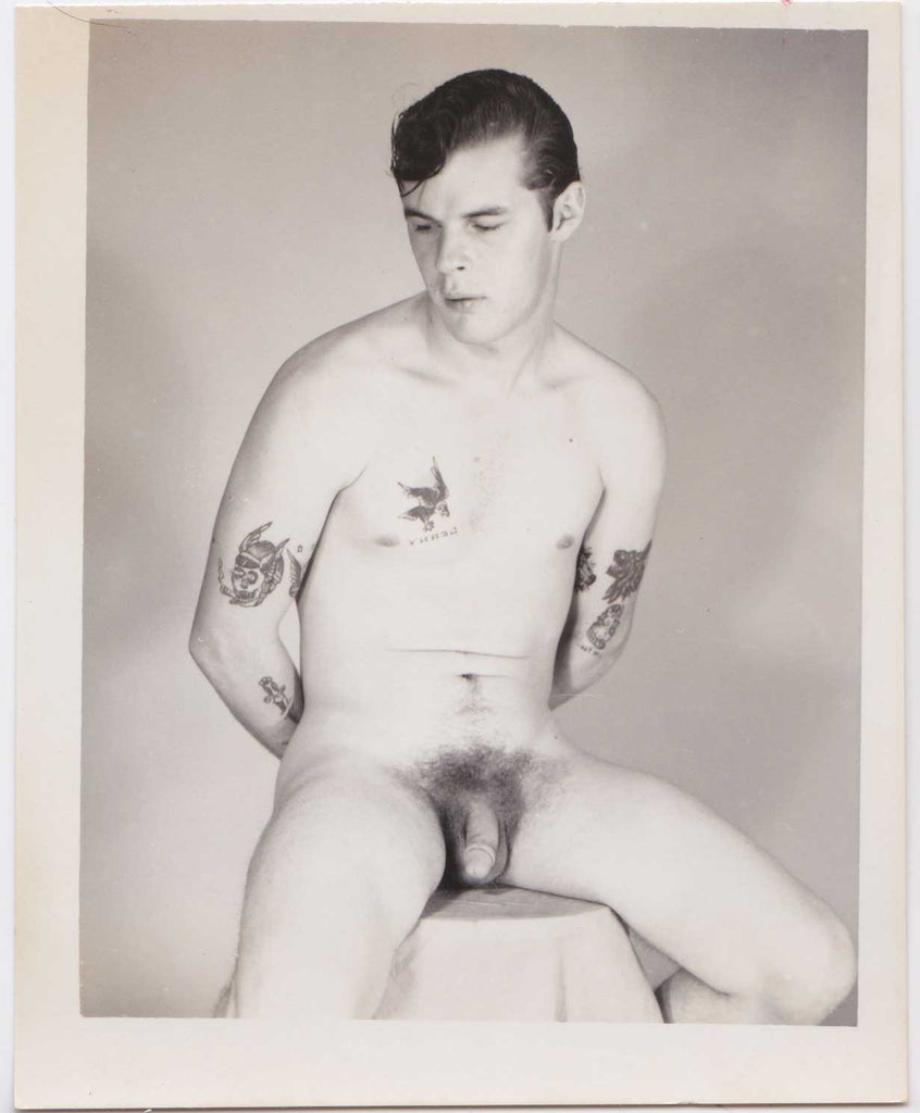 Seated male nude with an interesting assortment of tattoos. vintage gay photo