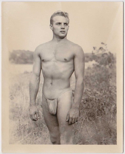 Standing in a natural setting, the model may be Johnny Buschard and the photo is attributed to Spectrum.