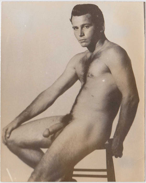 Naked Handsome hairy-chested guy seated on a stool. vintage gay photo
