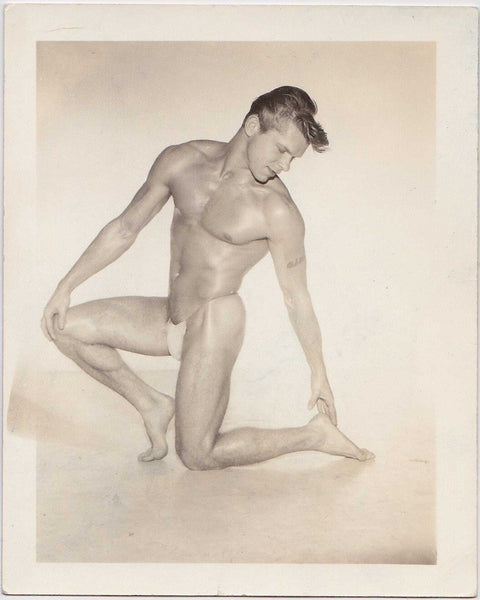 vintage gay photo A handsome young man with a great swoop of hair, naked except for his tiny posing strap. 