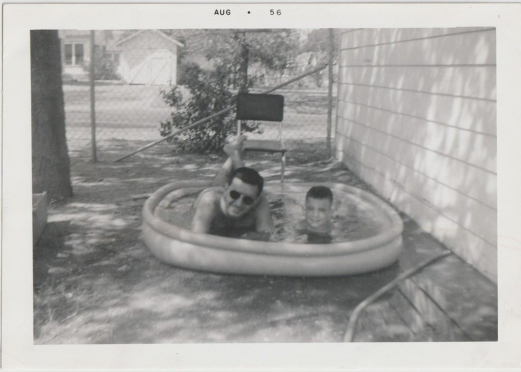 Father and Son Lying in Inflatable Pool