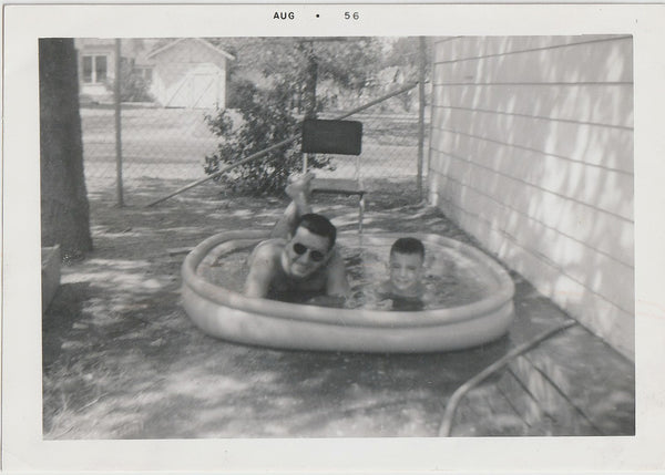 Father and Son Lying in Inflatable Pool
