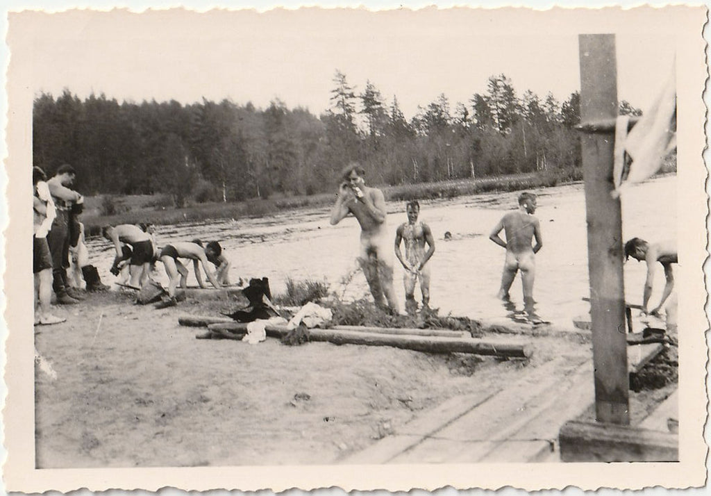Vintage gay snapshot of a group of guys in varying states of undress, several already getting soapy.