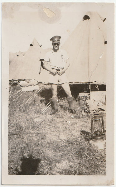 Vintage sepia photo Handsome studly soldier identified on verso as "Heals" poses in front of a row of tents with thumbs hooked onto his belt