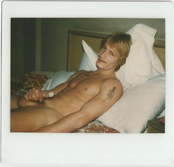 Handsome blond guy with dagger tattoo still holding onto his dick after he's come. vintage gay photo