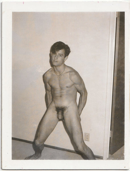 Handsome dark-haired guy does a partial crouch as he flexes vintage gay Polaroid.