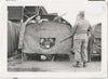 Husky guard identified on verso as "Manriges (Calif)" stands watch over five GIs in a not-very-secure tent.