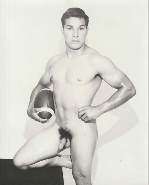 Handsome athlete Dave Sanchez poses holding a football, vintage gay physique photo by Dave Martin