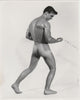 Black and white Bruce of LA gay physique photograph of a muscular nude male model from behind, holding a chain, Jim Conrey.