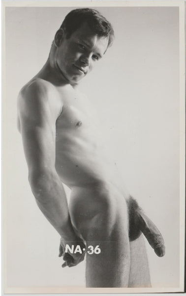 Black and white vintage physique photo of a handsome nude male model with the text 'NA-36' printed at the bottom.