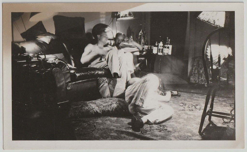 Strange and wonderful photo of three guys and a lot of empty booze bottles. 