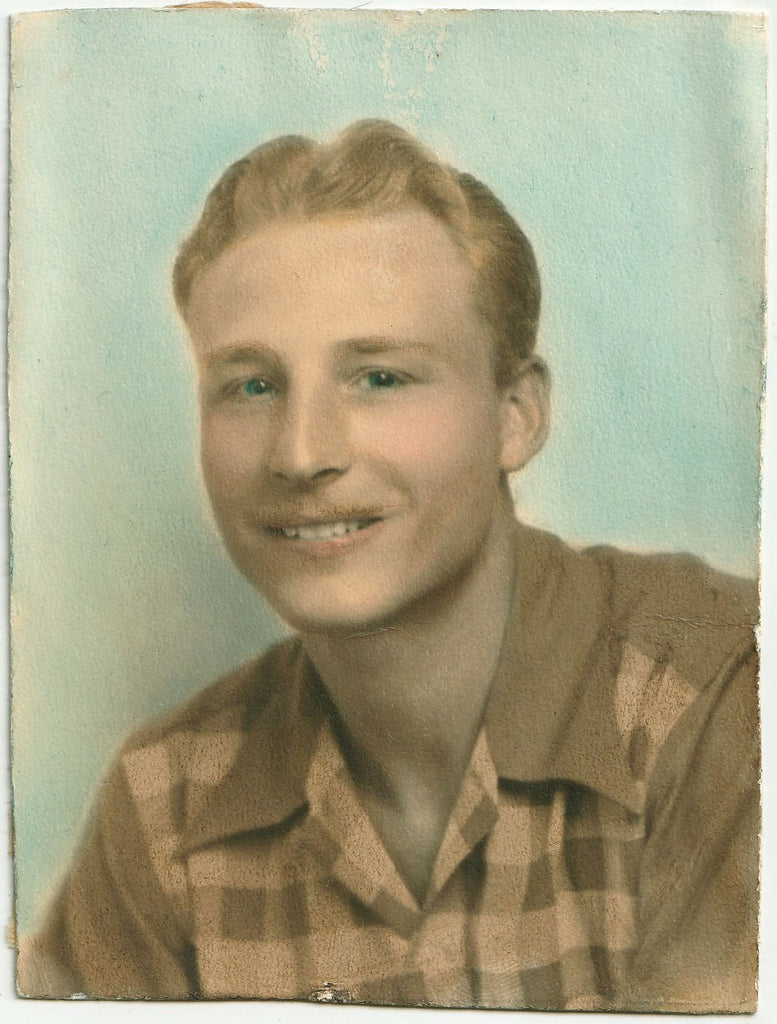 Handsome guy with wavy blond hair and an Errol Flynn mustache poses in his cool checked shirt.