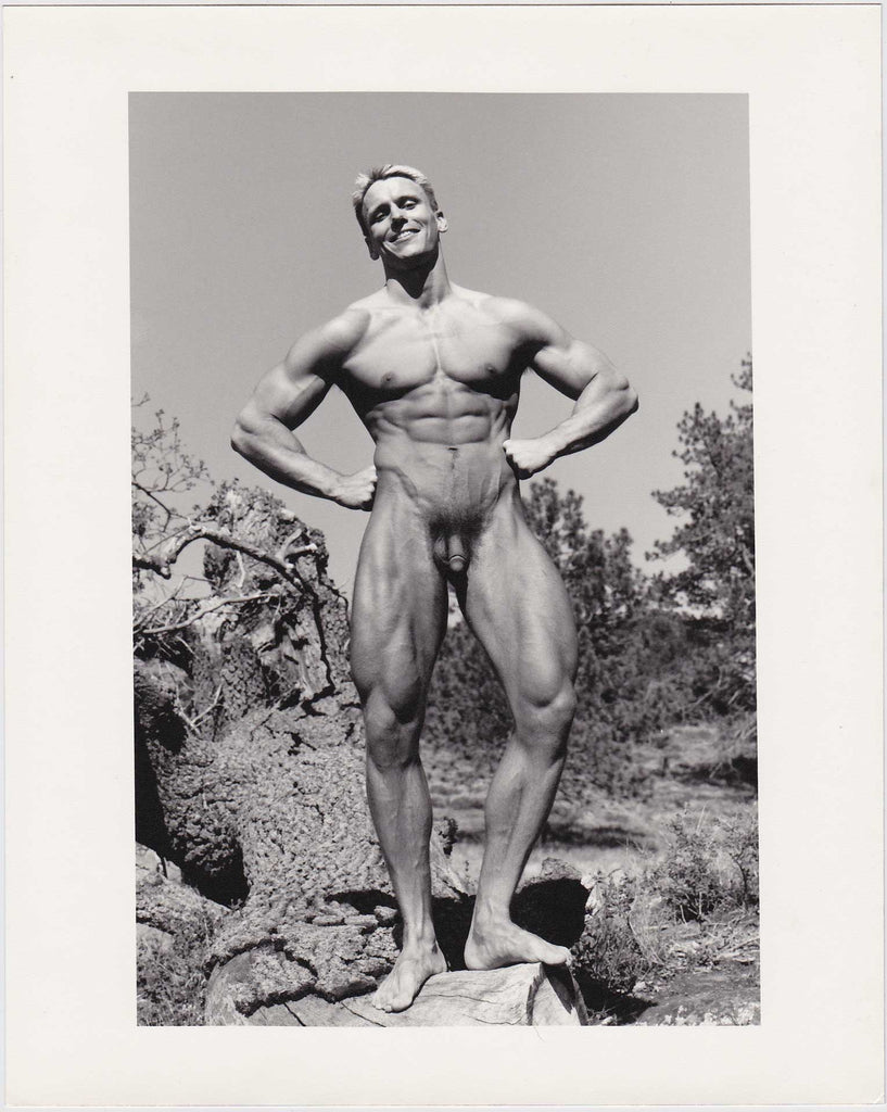 Beautifully printed photo of a handsome, smiling bodybuilder posing naked in the Southern California scrub. "Paul Burkhart, San Diego, Calif." 