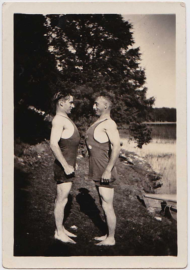 Two guys standing in their swimwear, looking like they're about to bump chests. Vintage gay photo.