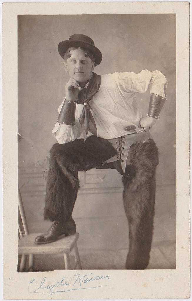 Handsome Clyde Kaiser wearing bearskin chaps and leather forearm bands. vintage sepia Real Photo Postcard, c. 1912.