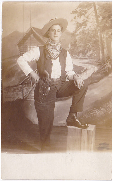 Handsome Cowboy Posing Before Log Cabin vintage sepia real photo postcard