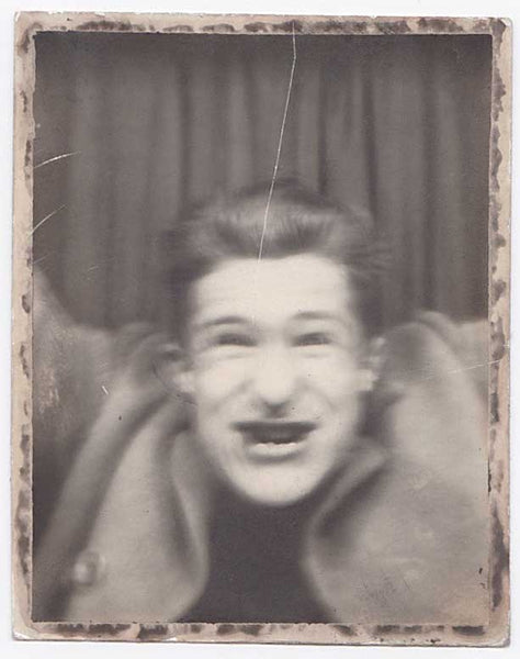 Blurry vintage photo booth photo of a young guy acting crazy.