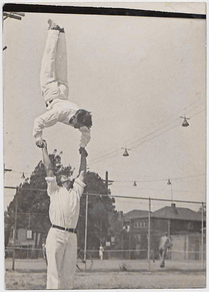 Hand balancers practicing near the tennis court vintage snapshot