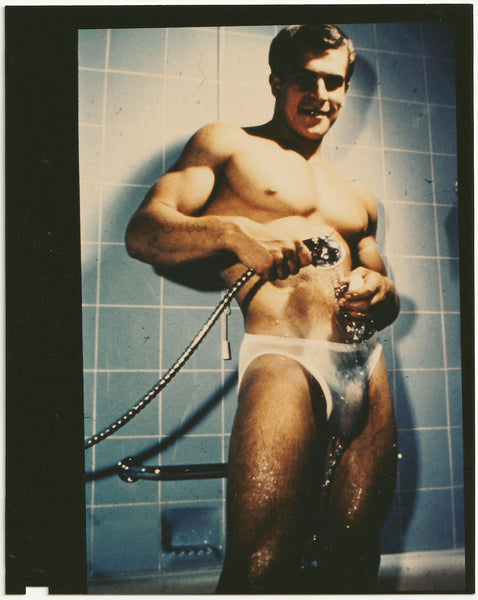 Handsome muscular young Helmut stands in the tub, holding a shower wand sprinkling water on his posing strap. Vintage gay physique photo.