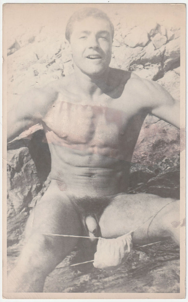 Handsome Jean Pierre Martin has lowered his posing strap as he offers a knowing look. Physique photo by Barrington
