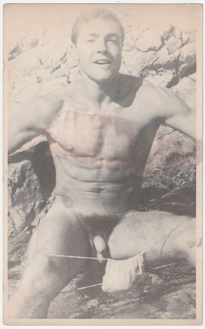 Handsome Jean Pierre Martin has lowered his posing strap as he offers a knowing look. Physique photo by Barrington