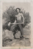 A more conventional view of a handsome and bare-chested man holding an axe. Vintage photo 1939.