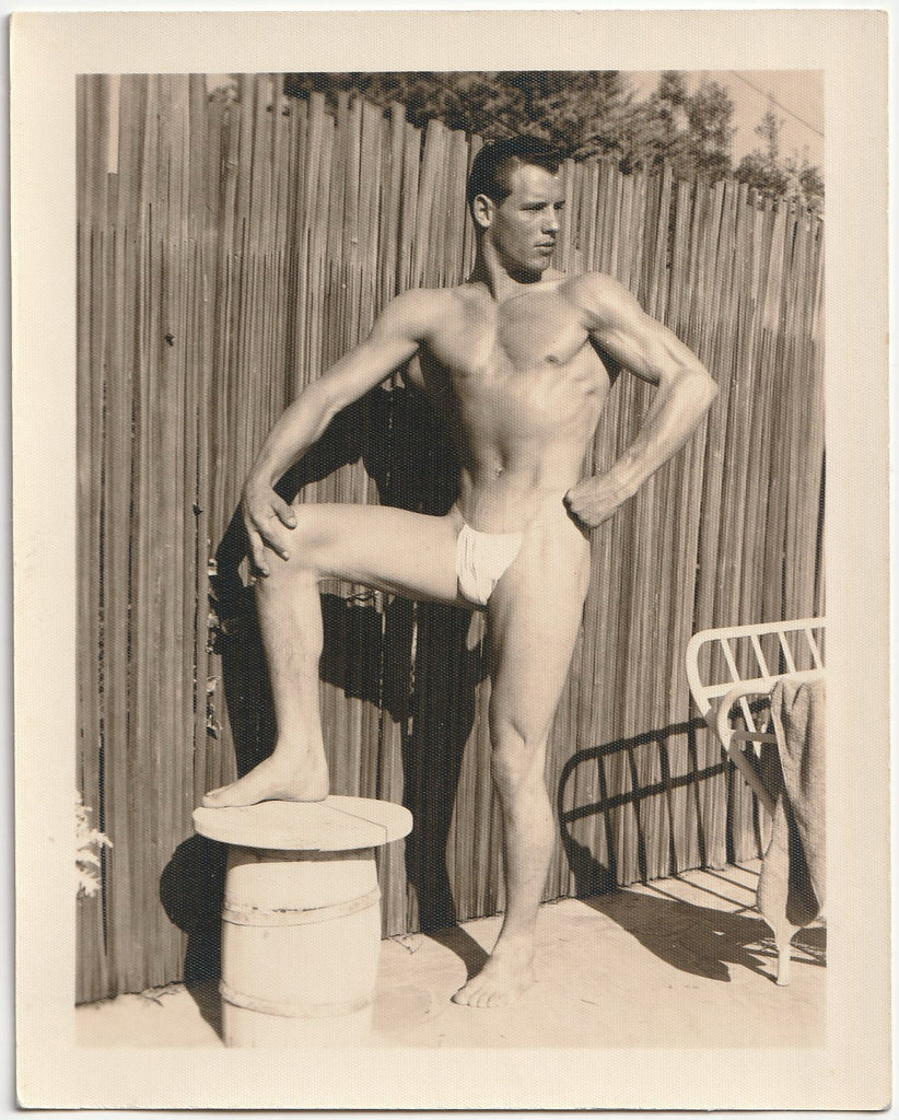 Male nude with taut muscles glistening in the sunshine vintage gay physique photo.