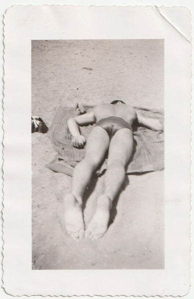 Vintage gay photo of man with big butt lying on beach towel.