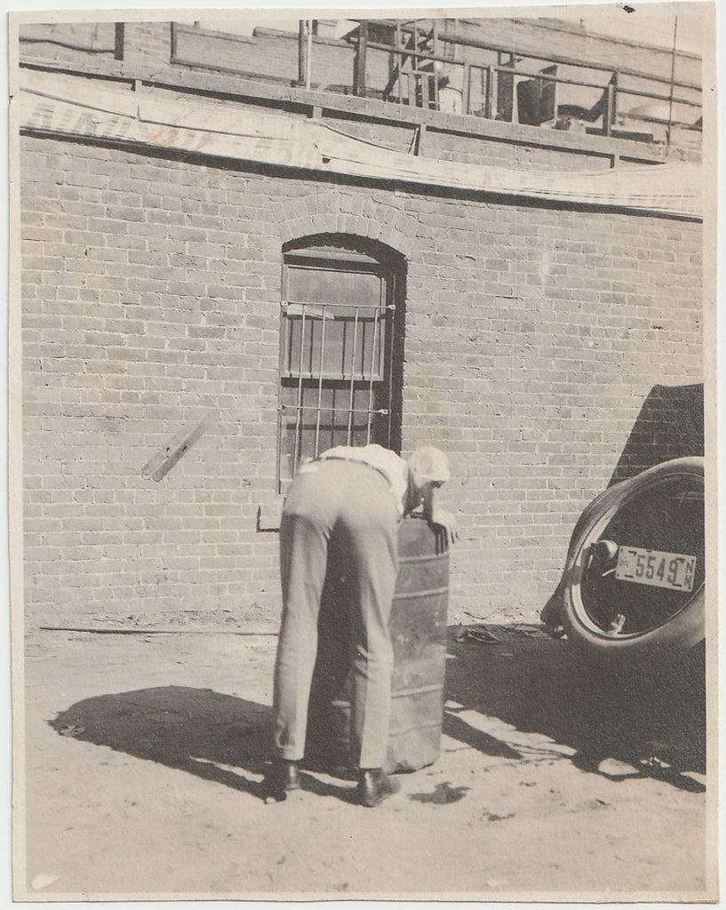 Man Reaching into Trashcan
