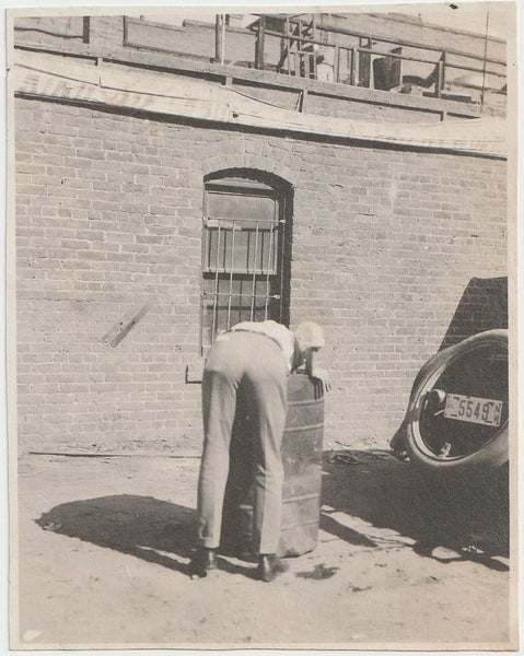 Man Reaching into Trashcan