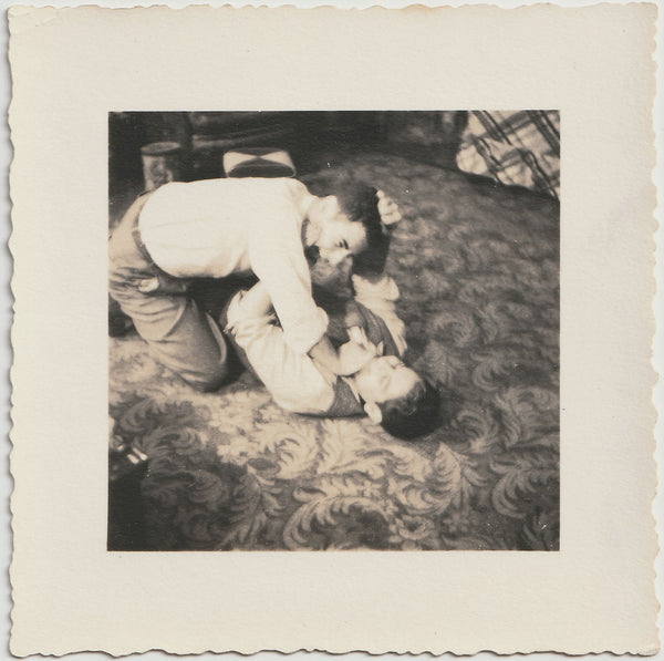 Two young guys wrestling on a fabulous floral carpet. 