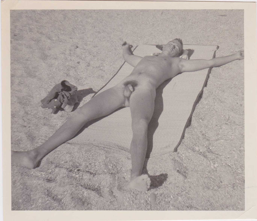 Vintage gay photo Naked guy with his clothes neatly piled to the side, he stretches out his arms and legs to allow sunlight into every crevice.