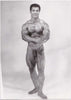 Vintage photo of handsome and muscular Mr. Universe 1964, Rick Wayne flexing in the studio.