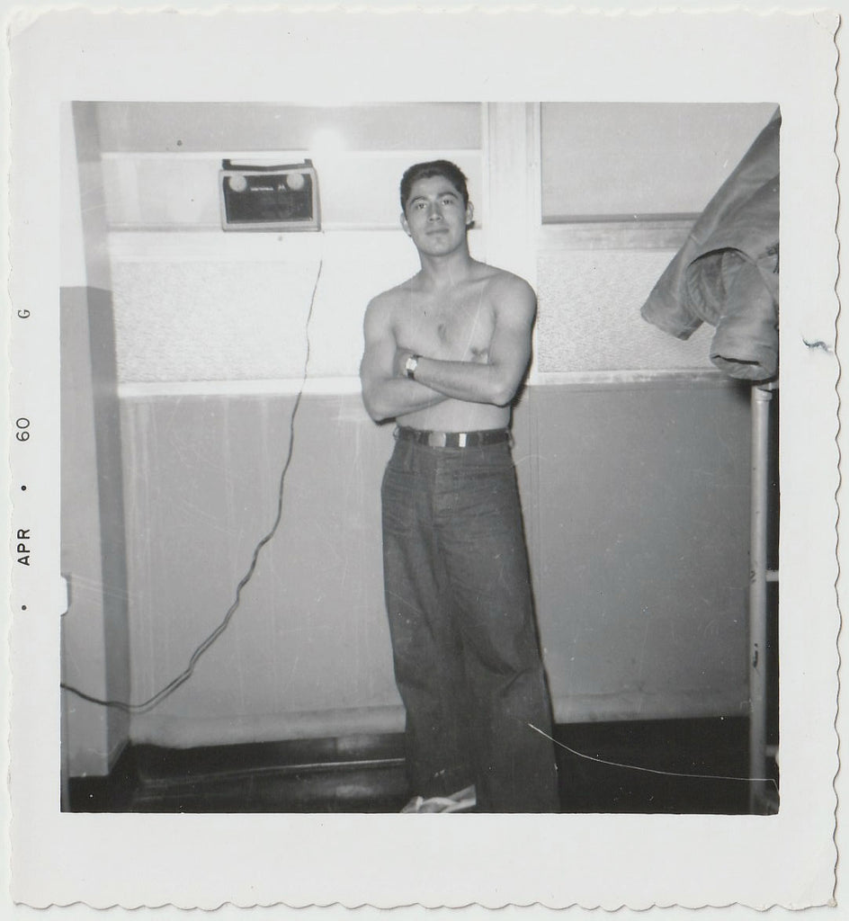 Good looking shirtless soldier poses with arms crossed, flip-flops on his feet.