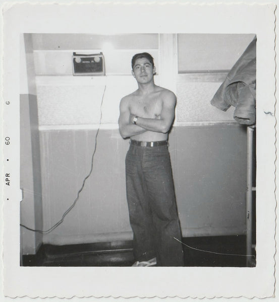 Good looking shirtless soldier poses with arms crossed, flip-flops on his feet.