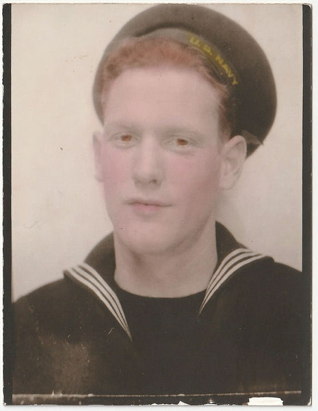 A vintage portrait of a young man in a U.S. Navy uniform wearing a cap.
